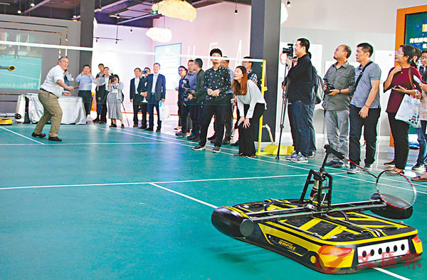 ■參訪團團員與機器人「小羽」打羽毛球。 香港文匯報記者李兵  攝